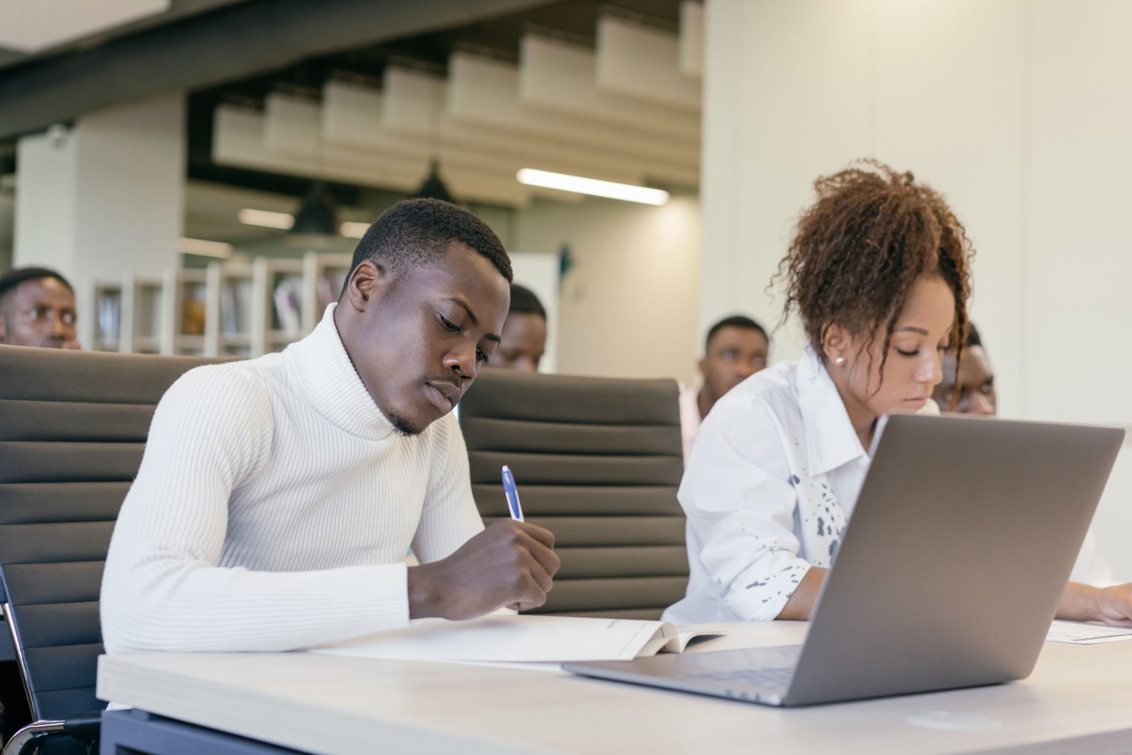 Diverse group of young professionals in a collaborative business meeting setting, actively participating.